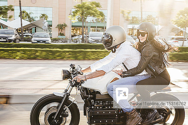 Couple riding motorbike in the city