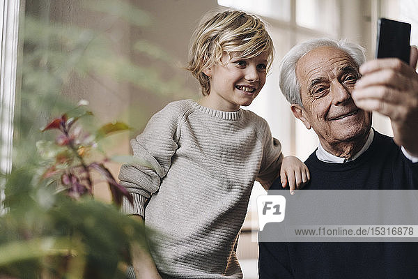 Glücklicher Großvater und Enkel  die zu Hause ein Selfie machen