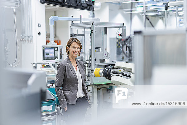 Porträt einer lächelnden Geschäftsfrau in einer modernen Fabrik