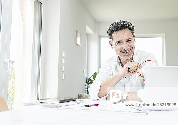 Architect sitting in bright office using laptop
