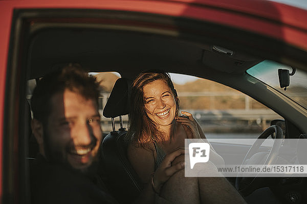 Glückliches Paar auf einer Autoreise mit Blick aus dem Autofenster