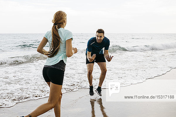 Female jogger on the beach with her coach