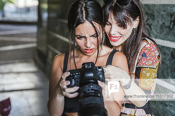 Zwei junge Frauen überprüfen Fotos auf einer Kamera