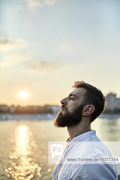 Bildnis eines Mannes mit Bart an einem Flussufer bei Sonnenuntergang