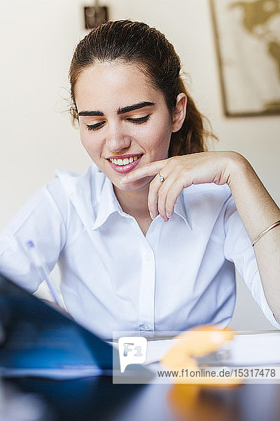 Smiling female student learning at desk at home
