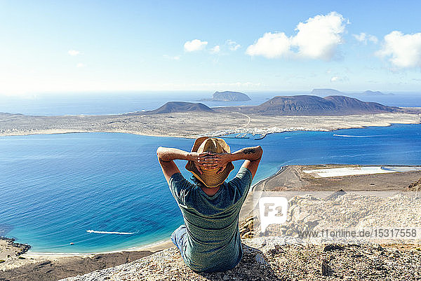 Man on viewpoint looking to La Gracioas island from Lanzarote Canary Islands Spain