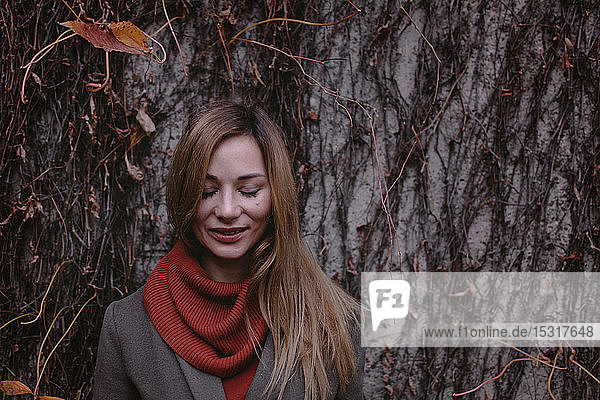 Porträt einer lächelnden Frau mit geschlossenen Augen im Herbst