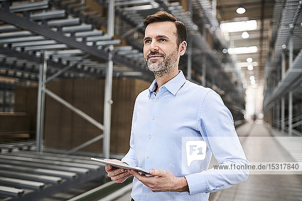 Confident businessman using tablet in a factory