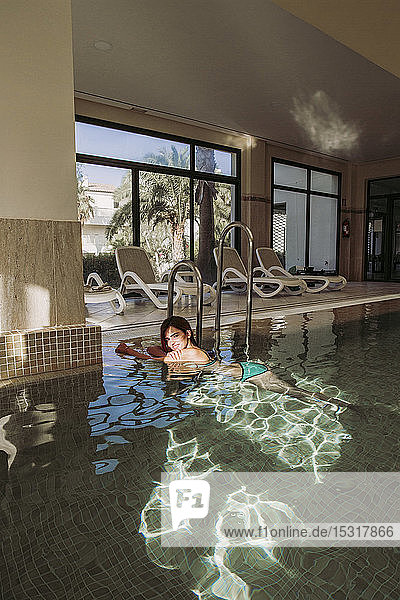 Young woman relaxing in swimming pool of a spa