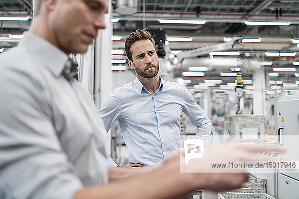 Two businessmen in a modern factory