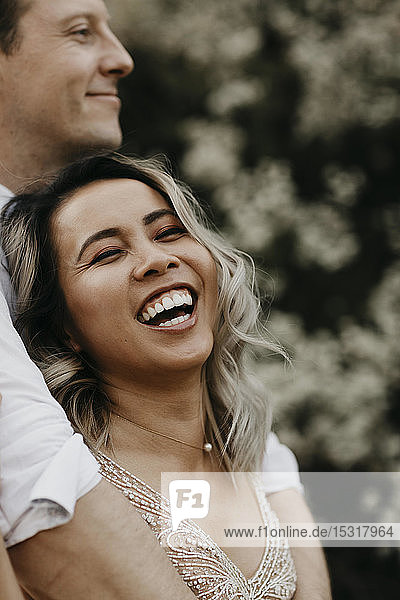 Portrait of laughing bride and groom outdoors