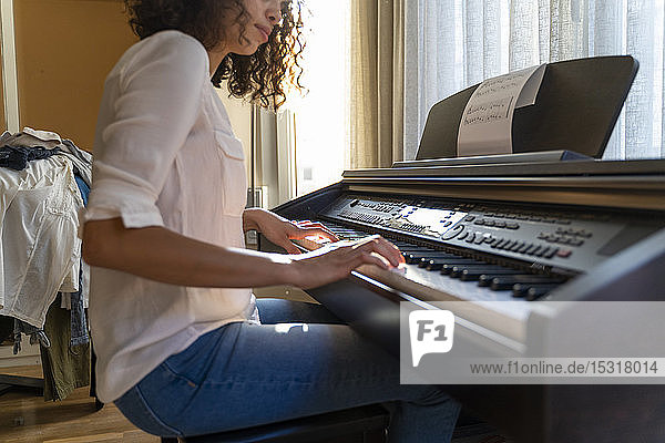 Frau spielt zu Hause Klavier