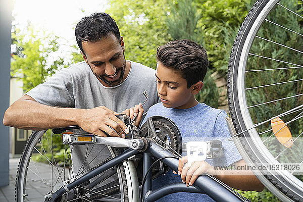 Vater und Sohn reparieren gemeinsam Fahrrad