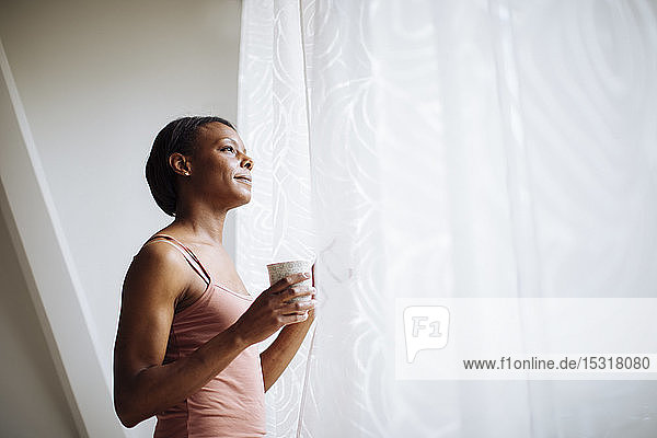 Woman at home looking out of window
