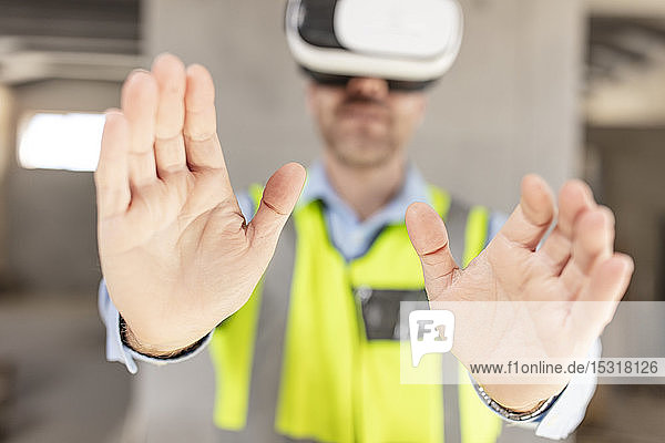 Architekt mit VR-Gläsern auf der Baustelle