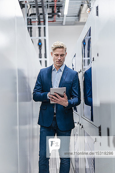 Businessman using tablet in a modern factory