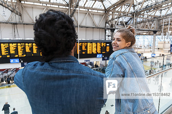 Glückliche junge Frau wartet mit ihrer Freundin am Bahnhof  London  UK