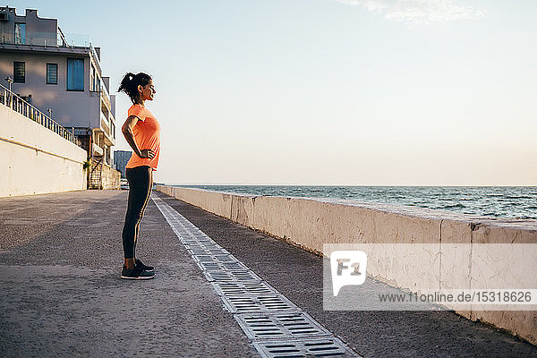 Sportswoman standing on a pier