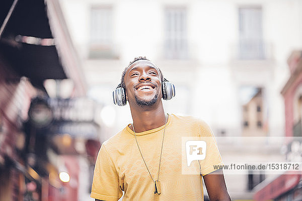 Porträt eines glücklichen Mannes  der mit Kopfhörern Musik hört
