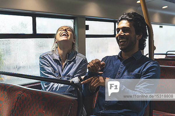 Junges Paar fährt an einem regnerischen Tag mit dem Bus und amüsiert sich  London  UK