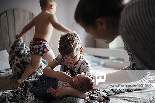 Mutter mit drei Kindern im Schlafzimmer