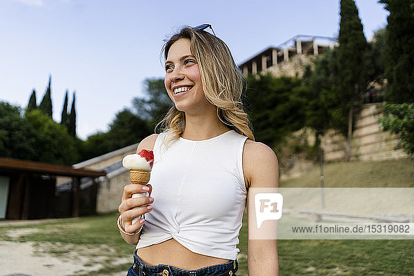 Porträt einer glücklichen jungen Frau mit Eistüte