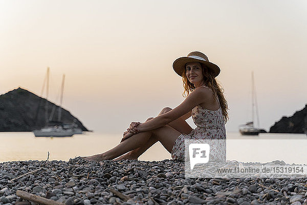 Junge Frau genießt Strand bei Sonnenuntergang