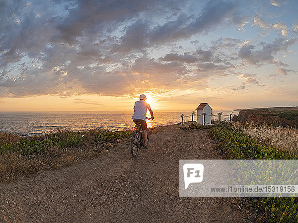 Portugal  Alentejo  senior man on e-bike at sunset