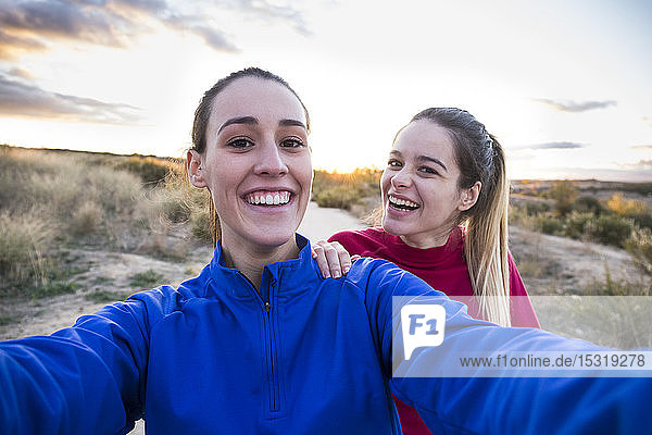 Junge Frauen in Sportkleidung nehmen Selfie mit Smartphone