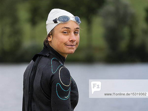 Portrait of a young female triathlete at a lake