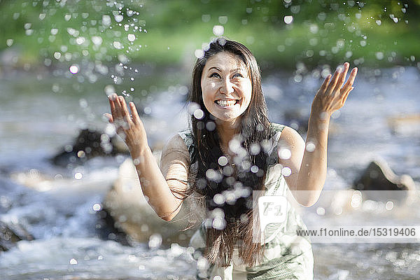 Junge Frau plätschert in einem Fluss
