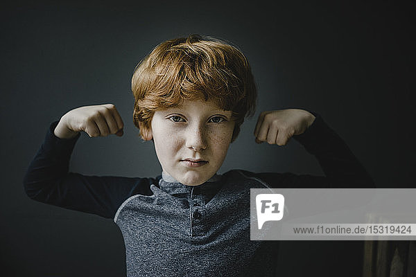 Porträt eines rothaarigen Jungen mit gebeugten Muskeln