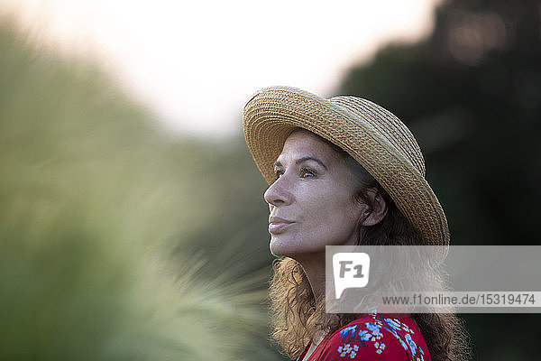 Porträt einer Frau mit Strohhut in der Natur