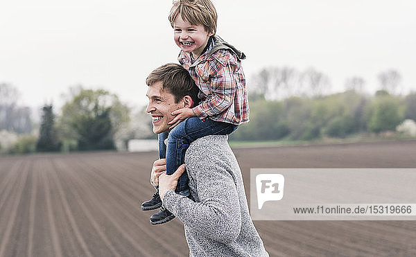 Father carrying son piggyback  walking outdoors