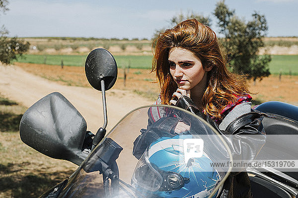 Portrait of redheaded woman on motorbike