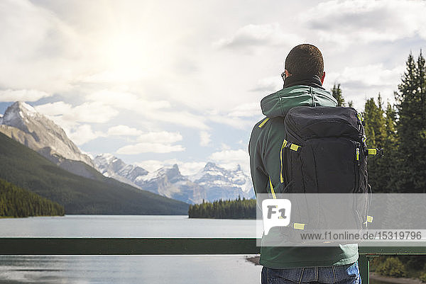 Tourist mit Rucksack geniesst die Aussicht über den Maligne Lake  Kanada