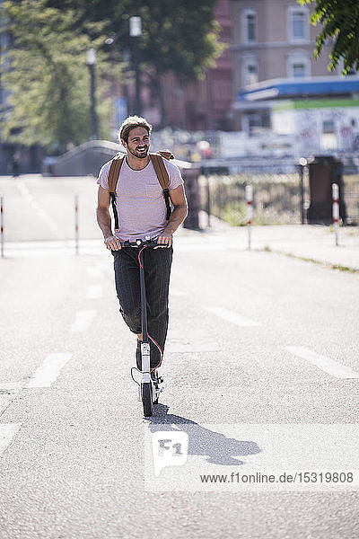 Young man riding electric scooter on the street