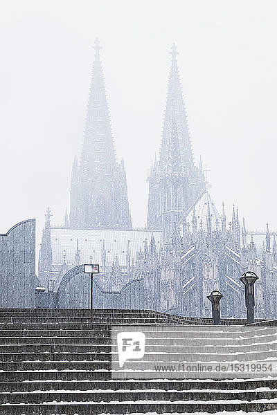 Tiefblick auf den Kölner Dom und das Museum Ludwig bei Schneefall in der Stadt gegen den Himmel