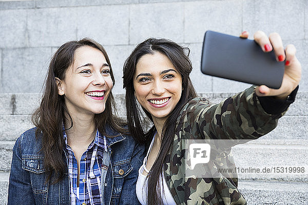 Smiling woman taking a selfie  sitting on steps