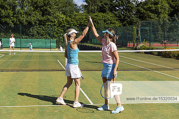 Glückliche reife Frauen feiern nach dem Tennisspiel