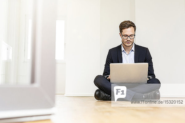 Businessman sitting on the floor using laptop