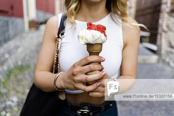 Hands of young woman holding ice cream cone