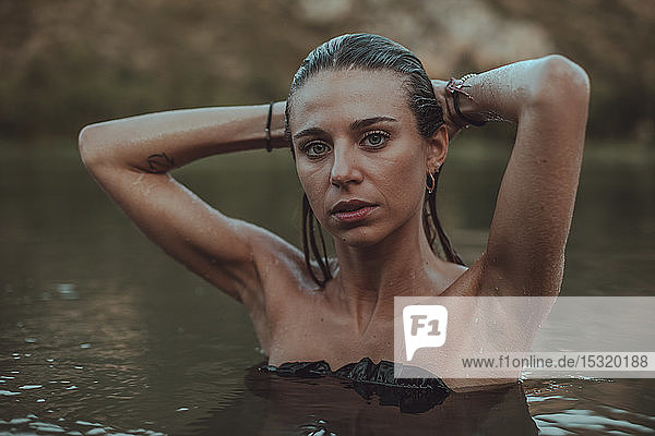 Porträt einer jungen blonden Frau  die in einem See badet