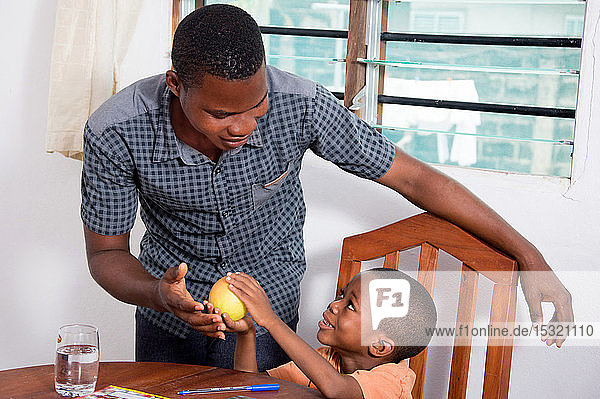 Dieses Kind zeigt seinem Vater den Apfel  weil es ihn essen möchte.
