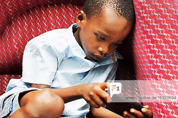 Dieses Kind ist sehr konzentriert auf sein Spiel im Handy.