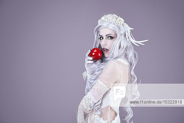 Young princess holding an apple in her hand