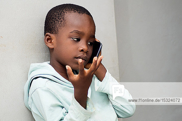This child questions himself with gestures on the phone with his mother or father.