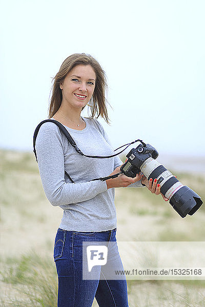 Young woman taking pictures at the beach