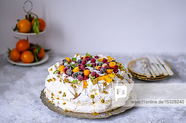 Pavlova-Torte mit gefrorenen Beeren und Kokosnuss auf einem Metalltablett