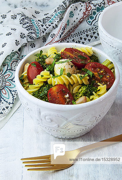 Eine Schüssel vegetarischer Pesto-Nudelsalat mit Mozzarella  Brokkoli und Tomaten